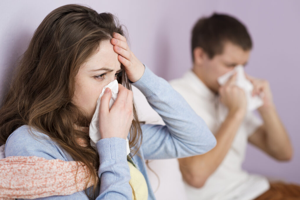 Woman and man sick with runny noses and fevers